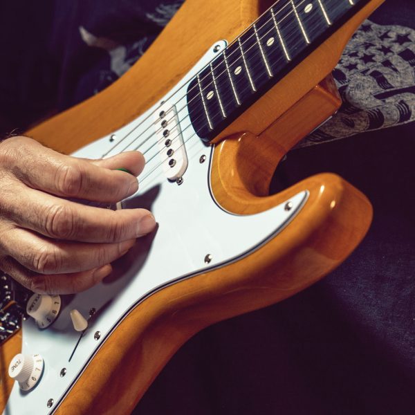 closeup of hand playing DSCO3913 electric guitar