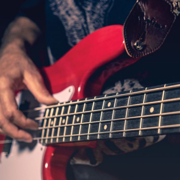closeup of neck of electric bass being played by man