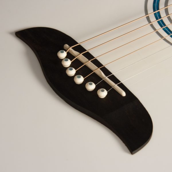 closeup of bridge on white Oscar Schmidt electric acoustic guitar